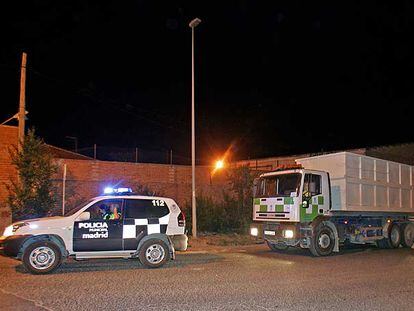 Un vehículo de la Policía Municiapl acompaña a varios camiones de basura a su paso por la Cañada Real Galiana.