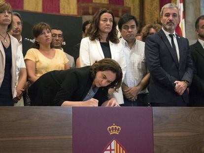 L'alcaldessa de Barcelona, Ada Colau, acompanyada d'autoritats, signa al llibre de condolences obert a l'Ajuntament.