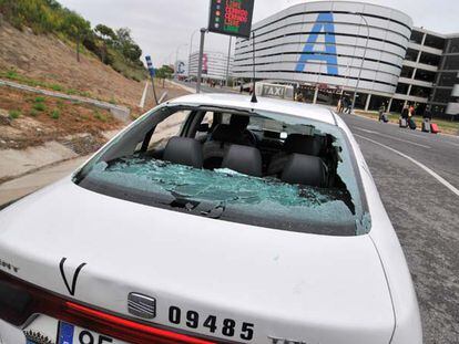 Los taxistas que siguen trabajando utilizan el aparcamiento de llegadas de la T-4 como alternativa para evitar los piquetes, pero los manifestantes lo ven y acuden a destrozar los cristales de uno de los vehículos. Mientras los usuarios caminan por la carretera.