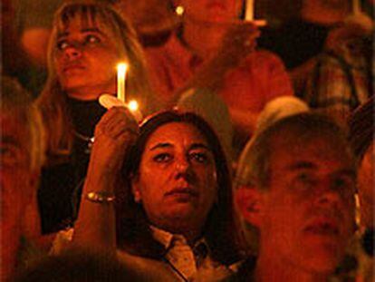 Los asistentes a la ceremonia inaugural encienden sus velas en memoria de los fallecidos por la enfermedad.