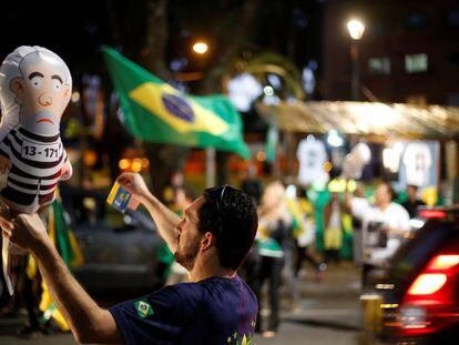 Un hombre sostiene un globo del expresidente Lula da Silva vestido como un reo en una manifestaci&oacute;n en Curitiba (Paran&aacute;)