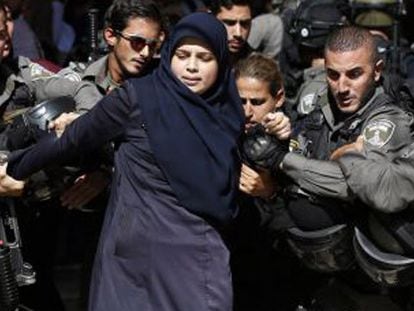 Las fuerzas de seguridad israelíes detienen a una mujer palestina.