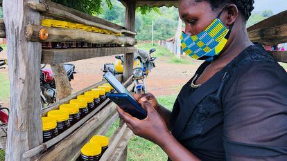 Una vendedora de miel usa su móvil en una pequeña aldea del condado de Baringo, en Kenia.