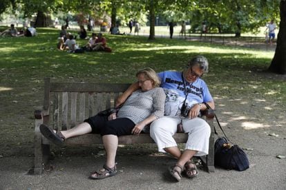 Una pareja se resguarda del calor en el St James's Park de Londres.