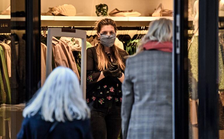 Una dependienta espera la entrada de clientes el primer día de reapertura de las tiendas en Essen, al oeste de Alemania