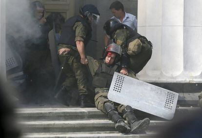 Un policía herido en los enfrentamientos entre la policía ucraniana y los nacionalistas es trasladado por sus compañeros al interior del Parlamento de Kiev (Ucrania). En la protesta ha muerto un miembro de la Guardia Nacional ucraniana y han resultado heridas un centenar de personas.