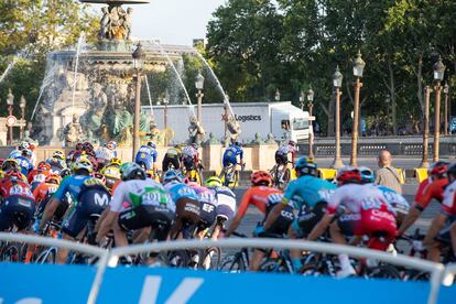 El pelotón del Tour, junto a un camión de la organización.