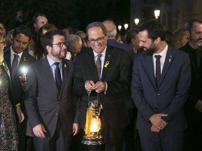 Torra (centro) sostiene la 'Flama del Canigó' junto a Pere Aragonés (izquierda) y Roger Torrent.