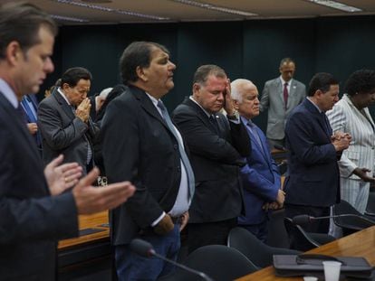 Un grupo de diputados brasileños reza en una sesión parlamentaria celebrada en su sede en Brasilia.