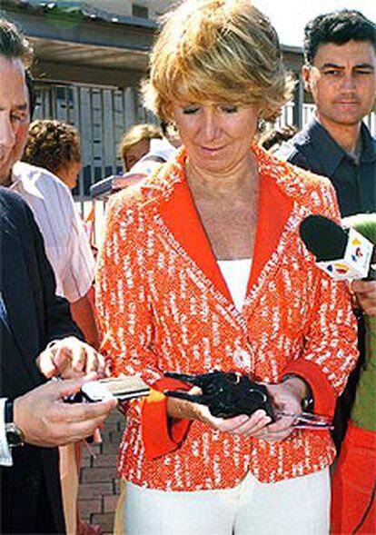 La presidenta de la Comunidad de Madrid prueba el nuevo brazalete electrónico.