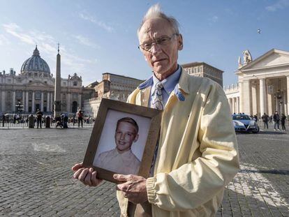 Phil Saviano, con un retrato suyo a la edad en la que sufrió abusos, en la plaza de San Pedro del Vaticano en 2019.