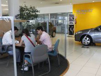 Unos clientes son atendidos por un trabajador en un concesionario de Renault.