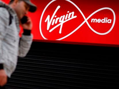 Un transeúnte  pasea frente a una tienda de Virgin Media cerrada por la covid-19 en Londres.