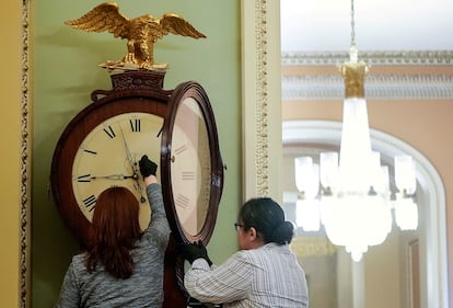 Dos trabajadoras del Capitolio ajustan un reloj, el 21 de enero de 2020.