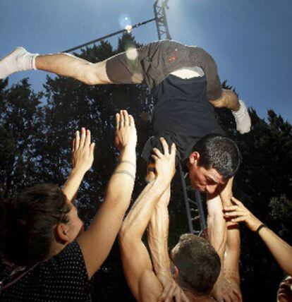 Alumnos de la escuela de circo, en la carpa de la Casa de Campo, realizan ejercicios de equilibrio.