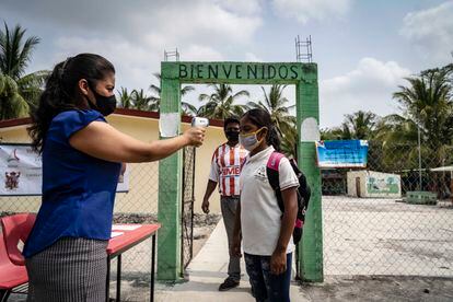 Aracely Muñoz toma la temperatura de Rubisela Hernández, alumna de la escuela Venustiano Carranza, ubicada en el municipio de Champotón, Campeche.