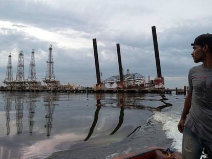 Un pescador navega junto a parte de la infraestructura en ruinas de una plataforma de la compañía petrolera estatal venezolana, PDVSA, en el lago Maracaibo en Cabimas, el 9 de mayo de 2019.