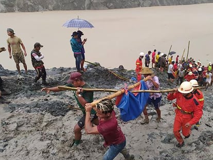 Voluntarios y trabajadores de los servicios de rescate trasladan un cadáver, este jueves en la región birmana de Hpakant.