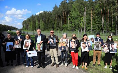 Miembros de Reporteros Sin Fronteras (RSF) y activistas posan ante la frontera lituana con Bielorrusia con fotos de periodistas bielorrusos detenidos por el Gobierno de Alexandr Lukashenko.
