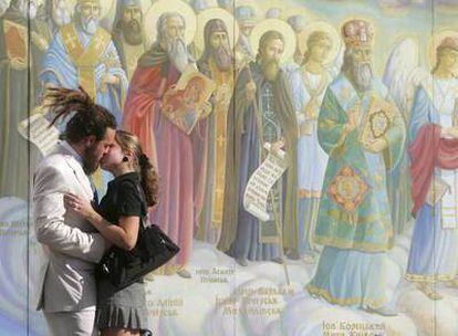 Una pareja se besa ayer ante los frescos de la catedral de Kiev, la capital de Ucrania.