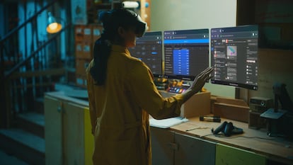 Someone working on the virtual screens they see in front of them using their Quest Pro.