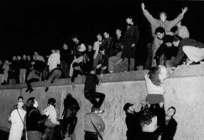 El 10 de noviembre de 1989, un grupo de jóvenes ayudan a otros a escalar el muro de Berlín.