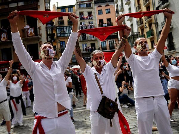 Pamplona, 06/07/2020 - Varias personas, vestidas de blanco y rojo, alzan sus pañuelos al aire a las 12:00 durante el no chupinazo de los Sanfermines 2020. Foto: Pablo Lasaosa