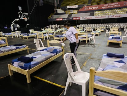 Una mujer desinfecta una cama habilitada para mayores de 65 años que serán alojados en el Palacio Peñarol en Montevideo, el 27 de marzo.