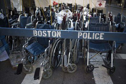 Sillas de ruedas utilizadas para poder tranportar a los heridos en el atentado del Maratón de Boston, permanecen tras un cordón policial.