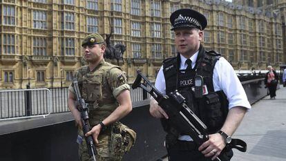 Un soldado brit&aacute;nico y un polic&iacute;a patrullan por los alrededores del Parlamento de Londres.