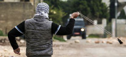 Un manifestante palestino arroja piedras con una honda a las fuerzas israel&iacute;es cerca de Nablus. 