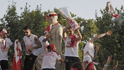 Los jugadores del Sevilla subidos a la estatua de Hispalis.