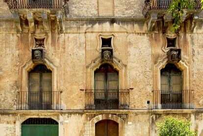 La fachada con tres m&aacute;scaras bajo tragaluces del Palazzo Bertini, en Ragusa. 