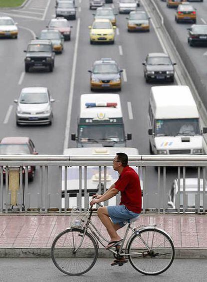 Un ciclista pedalea en un puente sobre un atasco de tráfico en Pekín