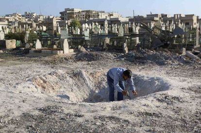 Un hombre inspecciona el agujero que ha dejado un ataque a&eacute;reo del r&eacute;gimen sirio en Idlib. 