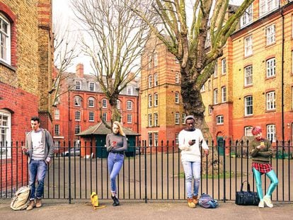 Jóvenes de distintas razas miran sus smartphones en Londres. 