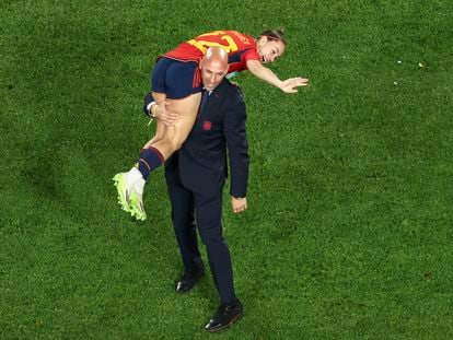 El presidente de la RFEF, Luis Rubiales, lleva sobre su hombro a la jugadora de la selección femenina Athenea del Castillo, tras la victoria de España en el Mundial.