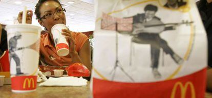 Una mujer come en un restaurante McDonald's.