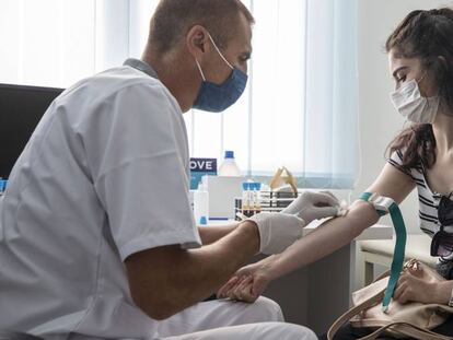 Un profesional de la salud toma una muestra de sangre para un test serológico de Covid.