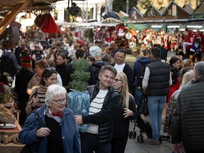 Varias personas realizan sus compras navideñas en el mercado navideño de la Fira de Santa Llúcia.