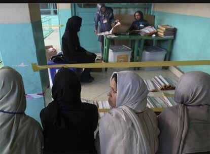 Varios afganos cuentan votos (en el fondo), mientras unas observadoras miran la mezquita que sirvió como centro electoral.