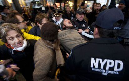 Policías retiran a un manifestante que bloqueaba el acceso a la bolsa de Nueva York.