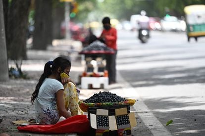 Una niña vende ciruelas en un puesto de carretera en Nueva Delhi, el pasado 30 de junio de 2021.