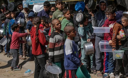 Niños palestinos desplazados internos hacen cola con sus recipientes a la espera de recibir alimentos proporcionados por donantes árabes y palestinos en la ciudad de Deir Al Balah, al sur de la franja de Gaza, el 24 de febrero de 2024.