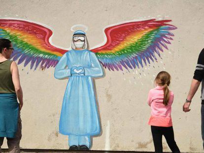 Una familia contempla un mural de la artista Rachel List que rinde homenaje al personal sanitario del Sistema Nacional de Salud británico, en Pontefract, Inglaterra. 