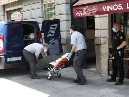 Dos trabajadores de una funeraria  recogen los cuerpos del hostal Levante.