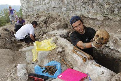 Uno de los participantes muestra uno de los cráneos hallados en la excavación.