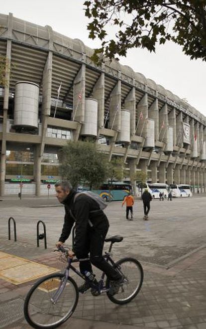 Un ciclista circula por delante del estadio Santiago Bernabéu.