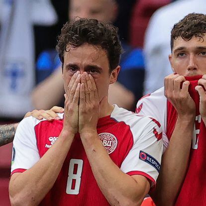 Denmark's midfielder Thomas Delaney and Denmark's defender Andreas Christensen react as paramedics attend to Denmark's midfielder Christian Eriksen after he collapsed on the pitch during the UEFA EURO 2020 Group B football match between Denmark and Finland at the Parken Stadium in Copenhagen on June 12, 2021. (Photo by Friedemann Vogel / various sources / AFP)