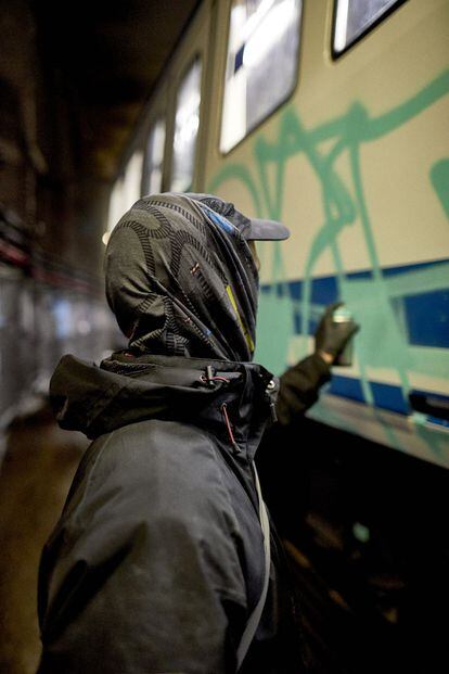 Un grafitero rellena las letras con su nombre. Utiliza pintura en aerosol hecha con base de agua. 